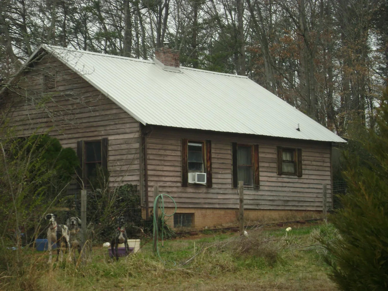 White metal roof on an old wood sided farmhouse, from a Asphalt Shingle Roof Repair job in Hugo